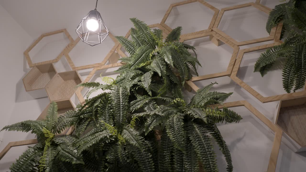 disparo de panorámica lenta de flores artificiales entre hexágonos de madera en una tienda