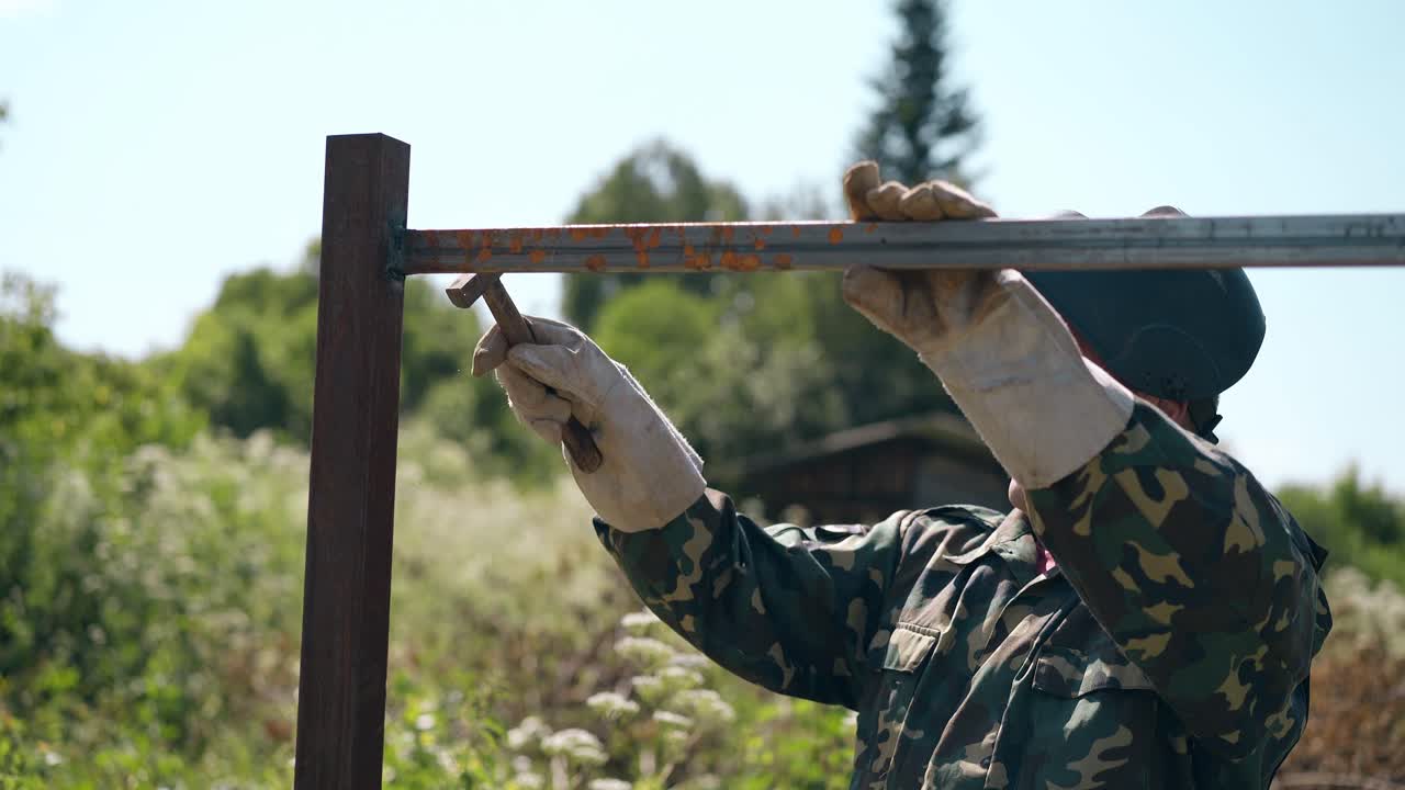 고정 된 울타리 세부 사항에 hummer와 함께 성숙한 handyman  ⁇