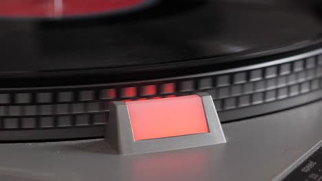 Slow-motion-close-up-shot-of-black-vinyl-record-that-starts-spinning-on-antique-turntable