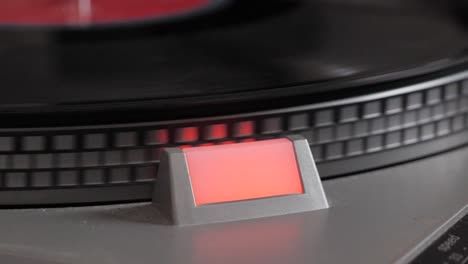 slow motion close up shot of black vinyl record that starts spinning on antique turntable