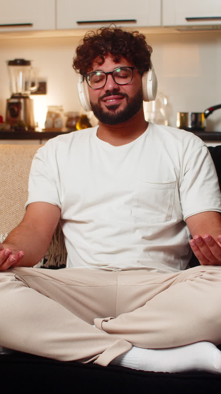 Uomo arabo con cuffie che medita con suono di pioggia, respirazione profonda, calma, relax, tranquillità, serata pacifica