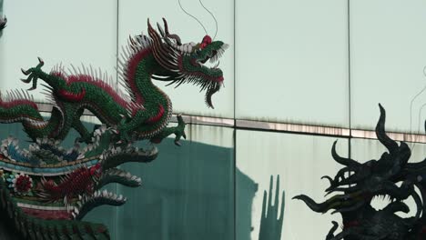 roof decorative sculptures at longshan temple with a modern building on the background