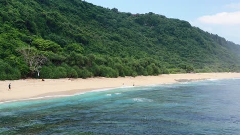 few-tourists-on-pristine-empty-white-sand-beach-at-Nyang-Nyang-in-Uluwatu-Bali,-aerial