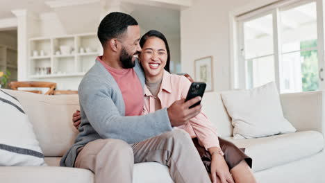 Pareja,-Abrazo-Y-Sonrisa-En-El-Sofá-Con-Teléfono-Inteligente