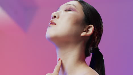 asian woman with black hair and make up with eyes closed, copy space, slow motion