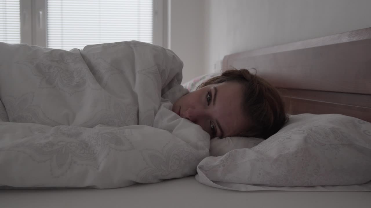 niña dormida abriendo los ojos despertándose por la mañana