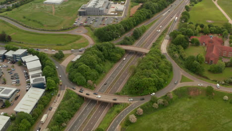 Circling-aerial-shot-of-raised-road-interchange-over-A1-Motorway-UK