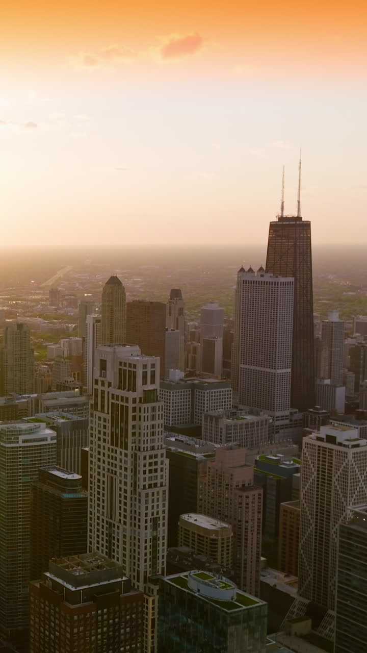 Setting sun over stunning Chicago, Illinois. Glorious skyscrapers in the rays of sun at sunset. Aerial perspective. Vertical video