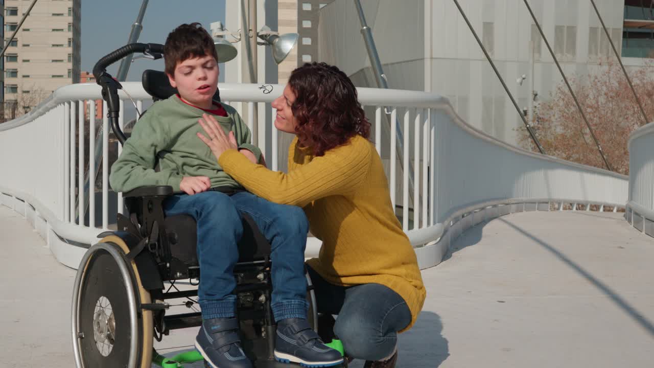 Woman and boy in wheelchair on bridge