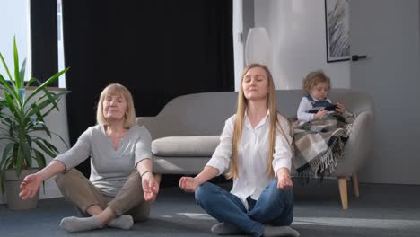 two women share a moment of leisure sitting on the floor with eyes closed two women are leisurely sitting crosslegged on the floor with their eyes closed sharing a moment of relaxation and fun at the event