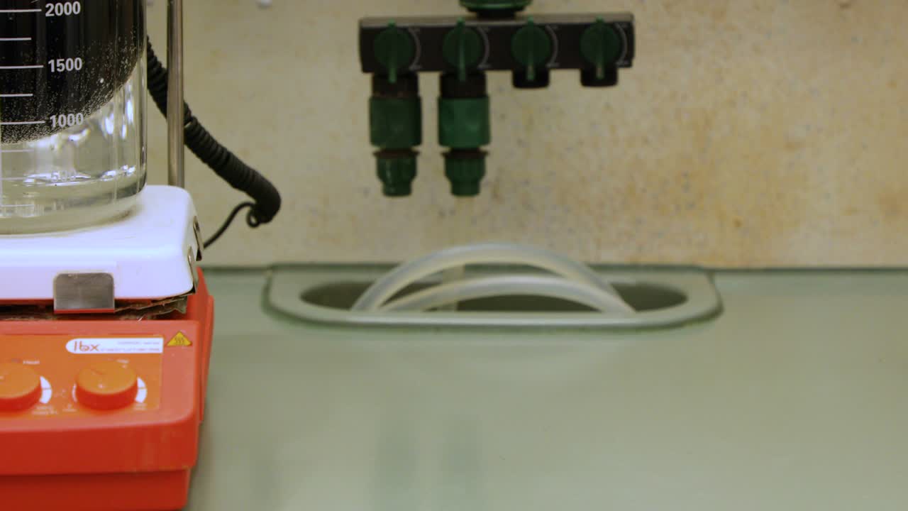 Stirring Chemical Solution In A Beaker Submerged In Ice For Cooling In Laboratory