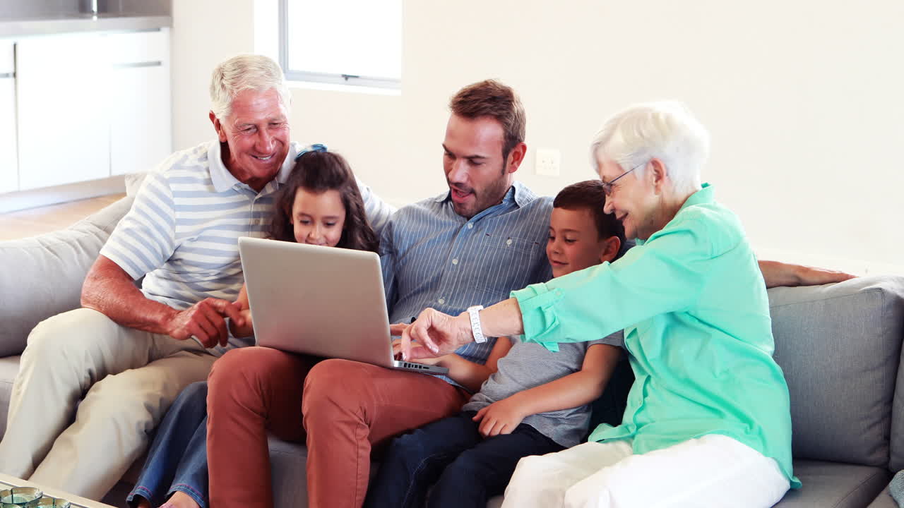 Happy multi generation family using laptop