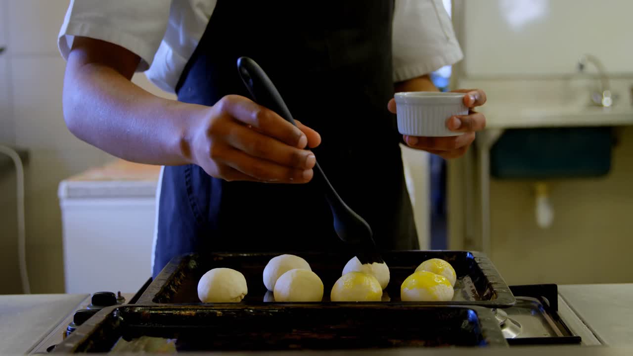 요리사 가 부 ⁇  4k 에서 반죽 에 기름 을 뿌리고 있다