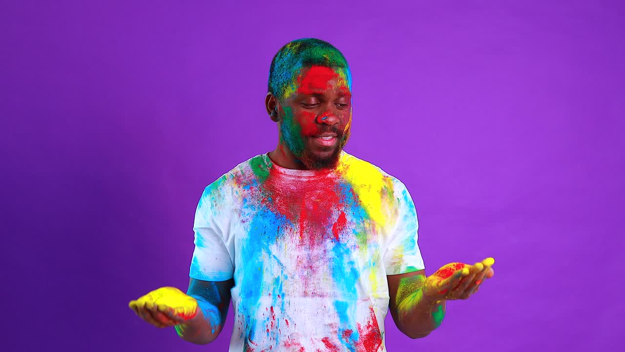 hombre latino brasileño en camiseta blanca de algodón con pintura colorida de la cara riendo estudio