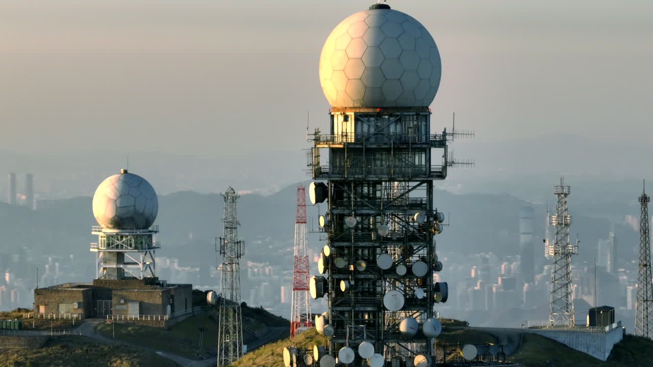 Aerial orbit shot of radome on top of Tai Mo Shan in Hong Kong at sunset - Shenzhen downtown in backdrop - Parallax