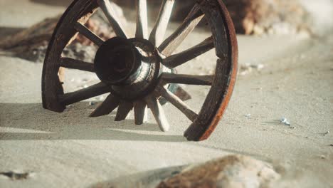 large wooden wheel in the sand