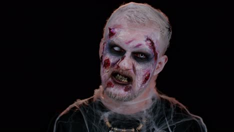 hombre aterrador con halloween zombie maquillaje herido de sangre, tratando de asustar, gritando, gritando