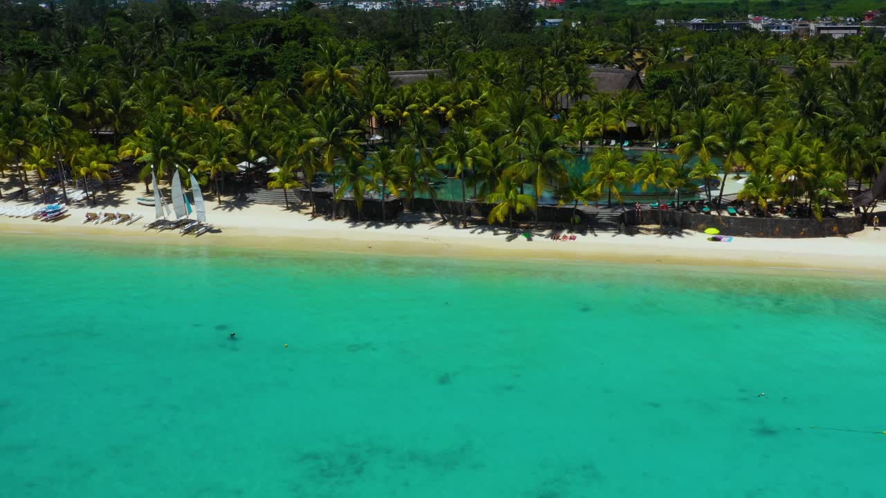 Spiaggia, barriera corallina e palme lungo il litorale di Mauritius, Africa. Molo vicino alla spiaggia dell'isola.