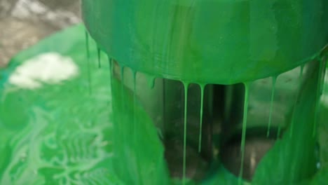 green paint dripping from container