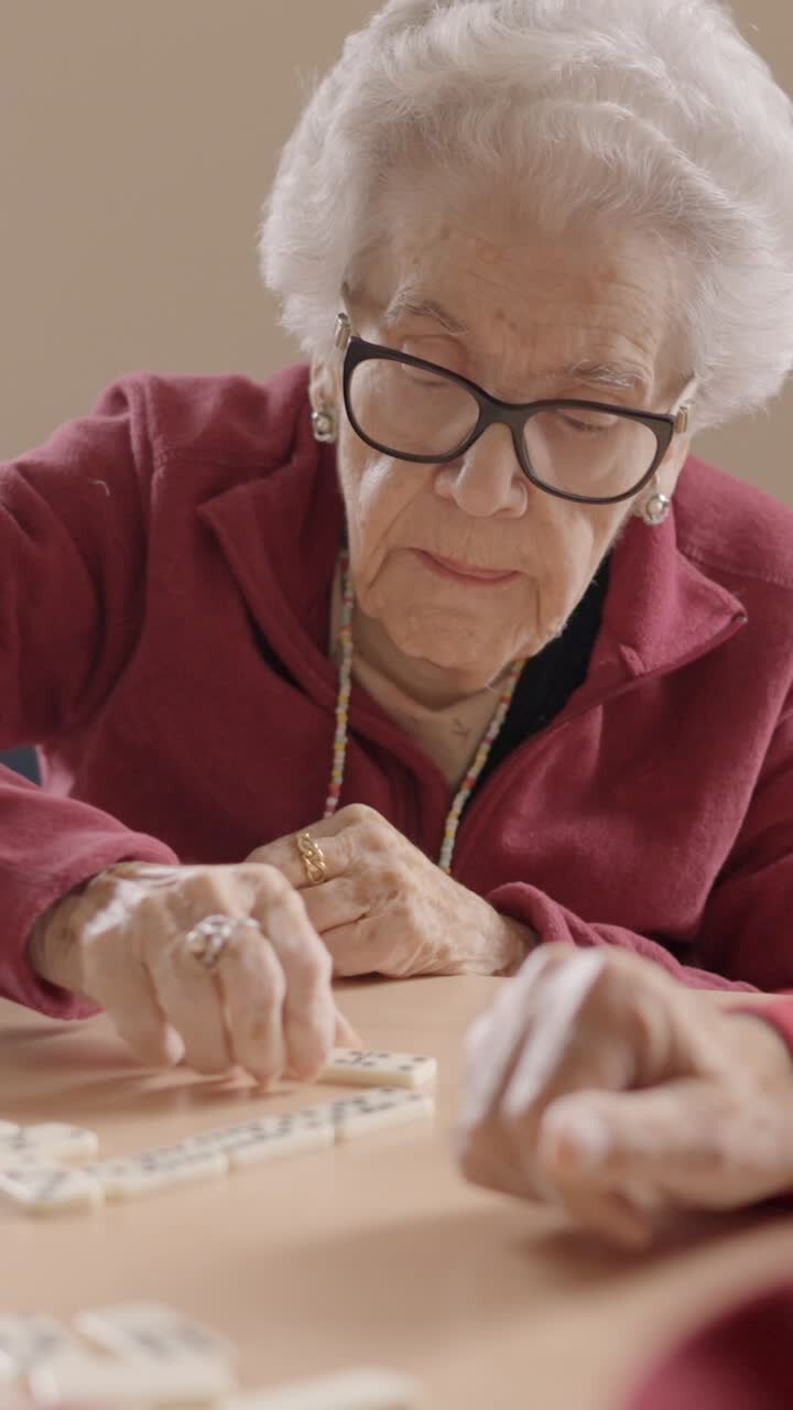 Senior people playing dominoes patiently in a nursing home