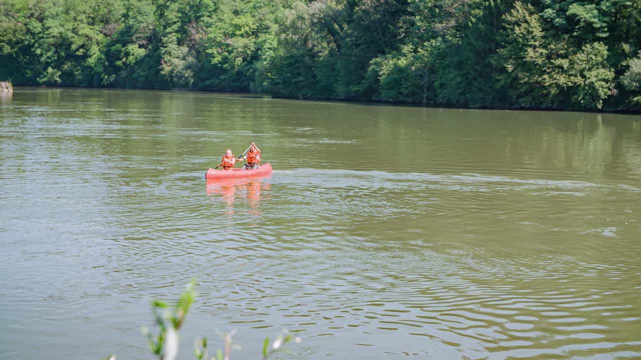 Coppia in canoa su un fiume calmo. Divertimento in famiglia e sport attivo. Rallentatore