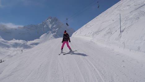 skier woman slowly skiing down on ski slope in mountain