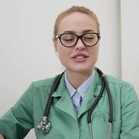 beautiful female doctor looking straight into camera while using video chat to communicate