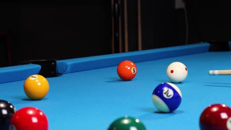 playing a game of billiards hitting the orange ball in with the cue ball