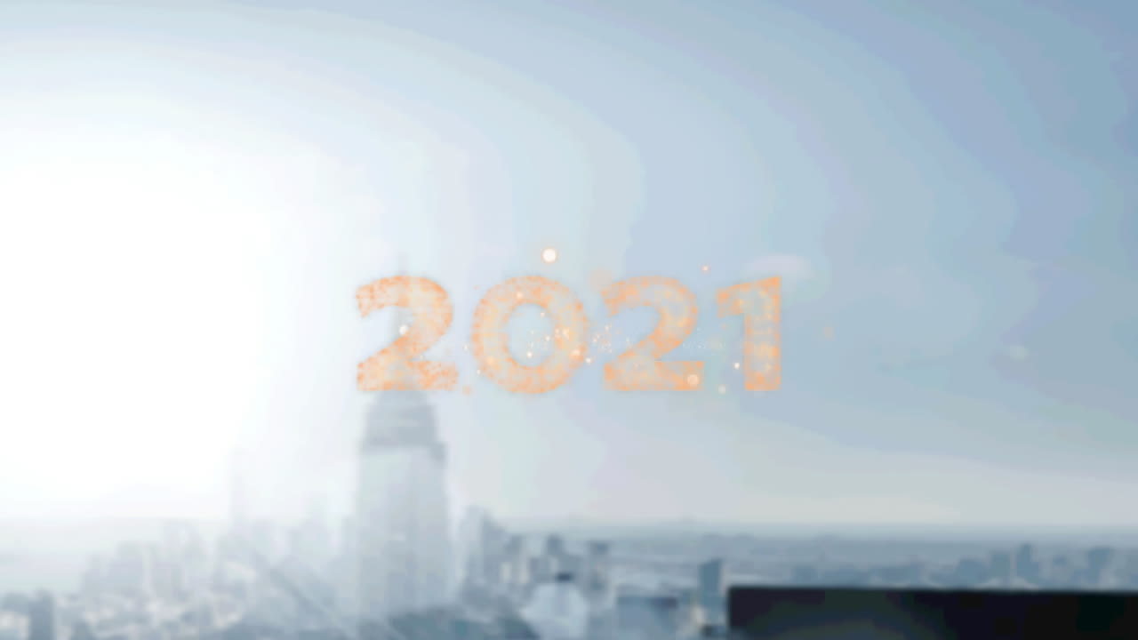 texto dorado de 2021 sobre fuegos artificiales explotando contra una vista aérea del paisaje urbano