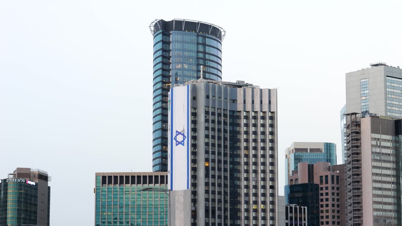 gran bandera israelí en rascacielos altos en el centro de tel aviv
