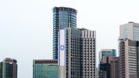 large israeli flag on tall skyscraper in downtown tel aviv