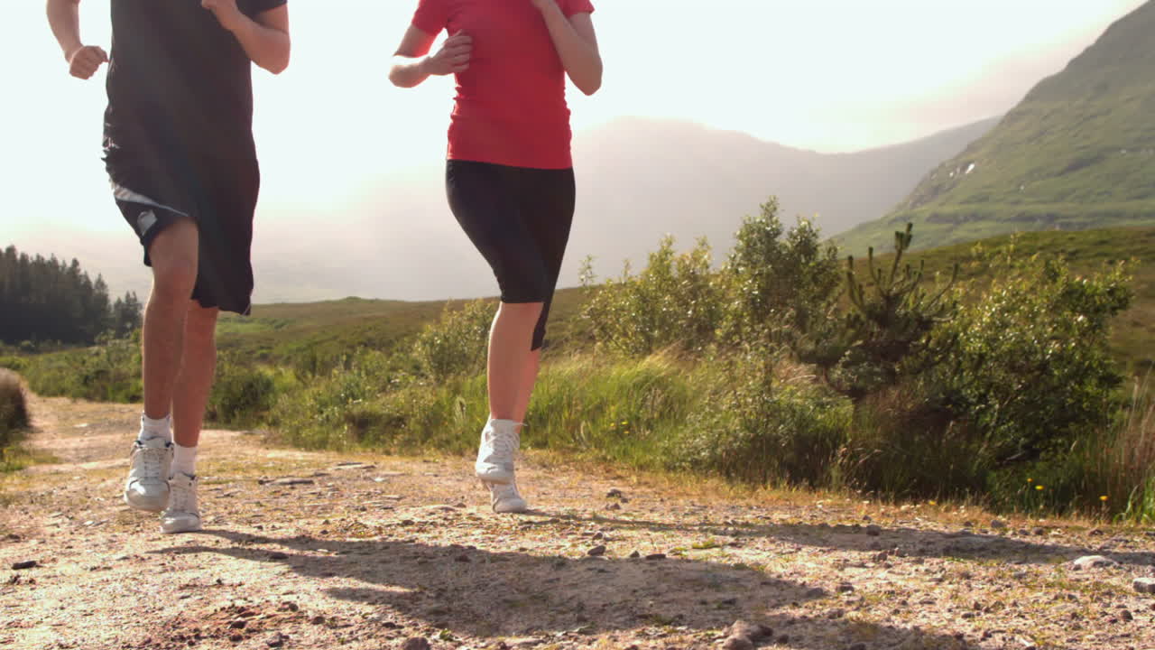 pareja en forma corriendo por un sendero de campo