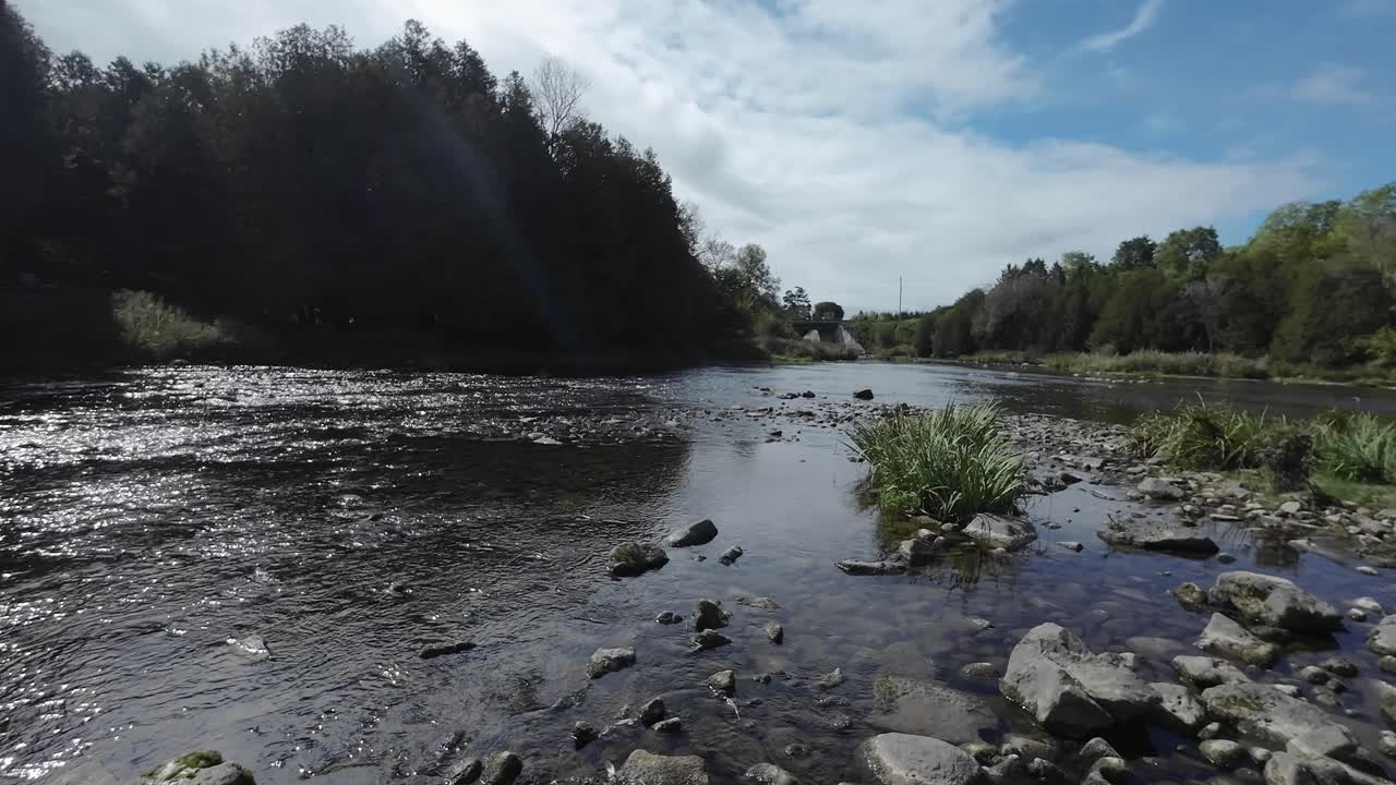 Water Flowing Downstream Along The Grand River At Fergus In Ontario, Canada. Panning Shot.
