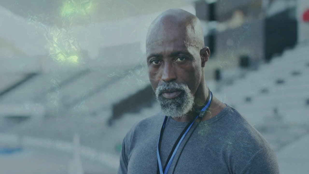 Standing in empty stadium, mature man with serious expression, thinking deeply
