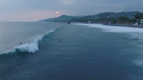 해가 지는 순간 에 서핑 하는 사람 들 을 천천히 보는 항공 사진 la bocana el tunco el salvador
