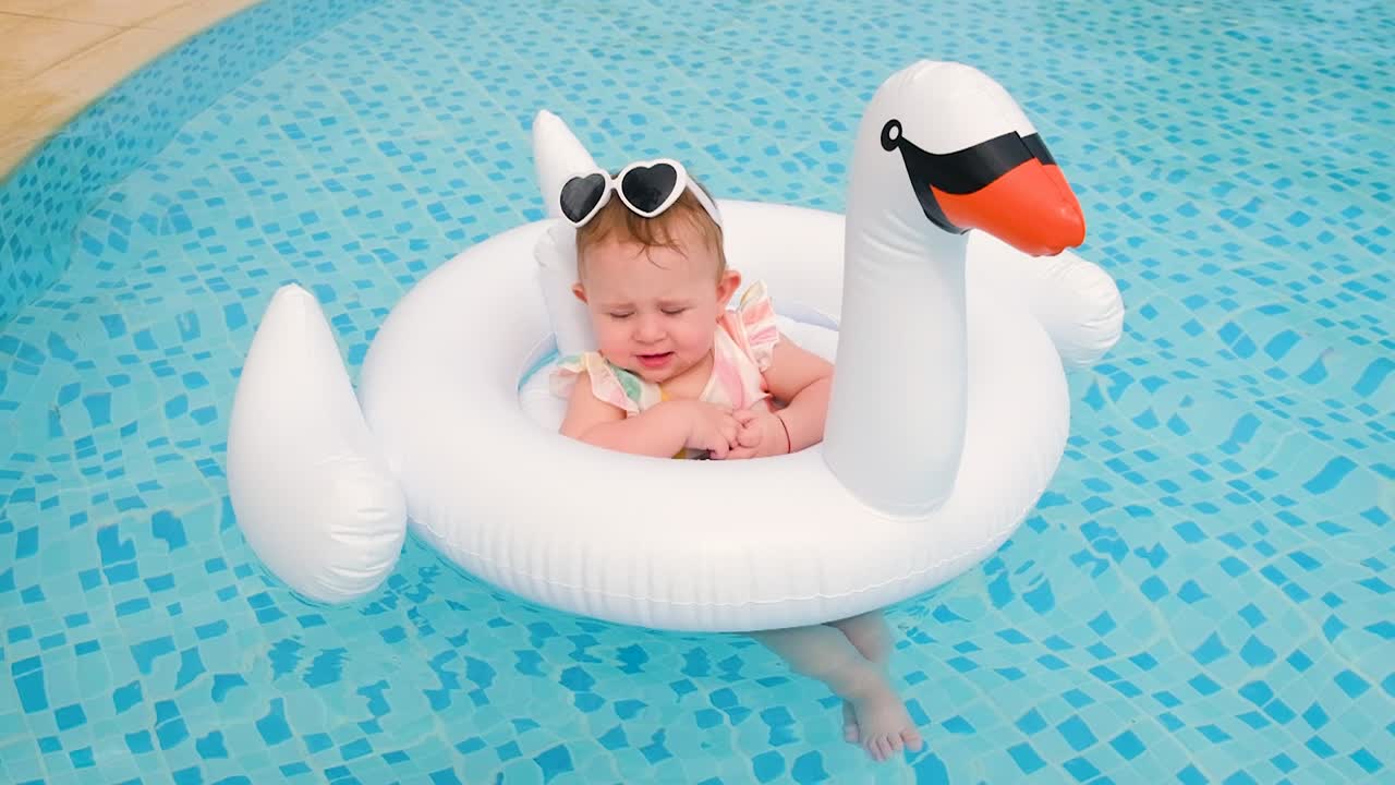 Baby swims in a circle in the pool. Selective focus.