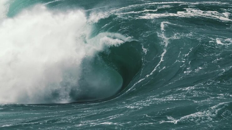Large heavy wave breaking onto a shallow reef. Slow motion.