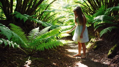 young girl exploring a sunlit fern forest path