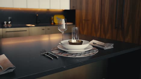 plate set up on a black kitchen island in a modern dark toned kitchen