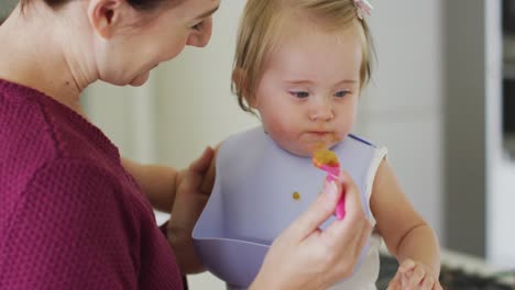 close up of caucasian mother feeding her baby at home