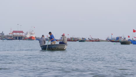 tracking shot of fishermen heading out to sea on a small traditional boat in da nang