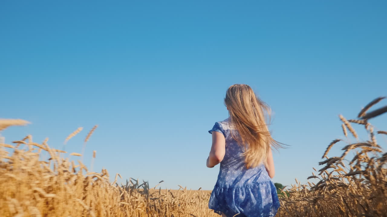 bebé feliz corre a través de un campo de trigo contra un cielo azul