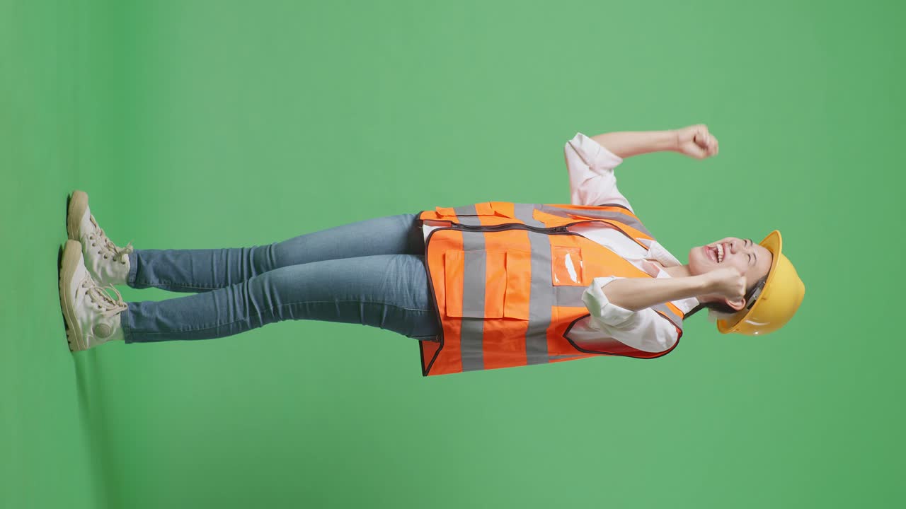 vista lateral completa del cuerpo de una ingeniera asiática con casco de seguridad gritando gol celebrando trabajando en el estudio de fondo de pantalla verde