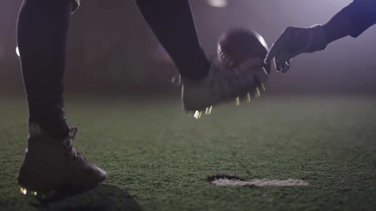 American Football Player Kicking Field Goal on Turf Field