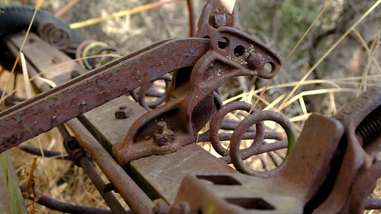 Antique hay rake full of rust. Closeup.