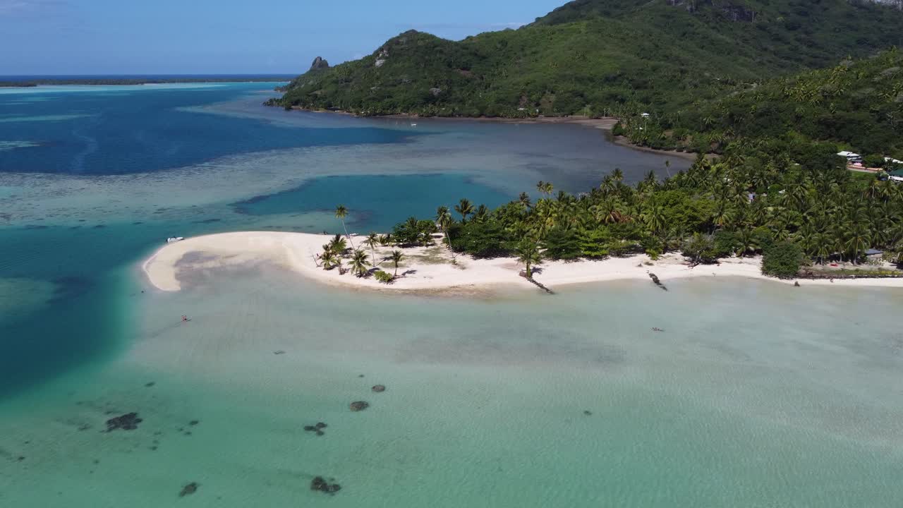 Flyover shallow coral atoll lagoon to sand beach in Polynesia paradise