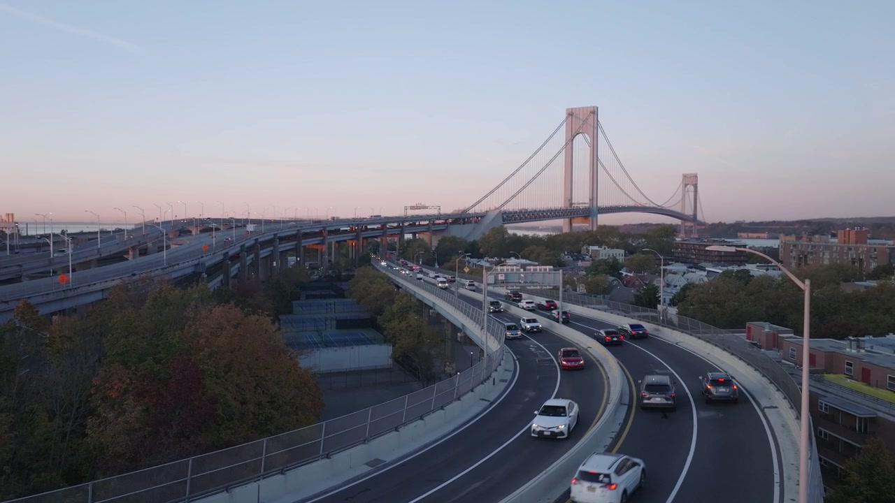 Ilmakuva liikenteestä ylittämässä Verrazano-Narrows Bridge -siltaa auringonnousun aikaan. Kuvattu syysaamuna Brooklynissa.