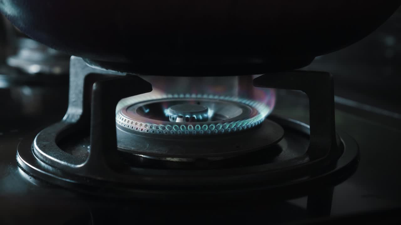 부에서 파란색과 빨간색으로 불타는 불꽃이 있는 검은색 가스 스토브의 비디오
