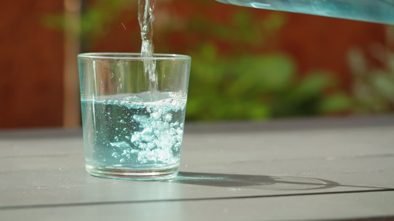 Wasser in ein Glas gießen