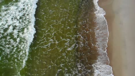 AERIAL:-Flying-Above-Coastline-While-Waves-are-Crashing-on-the-Shore,-Slow-Motion,-High-Speed-Camera,-120-FPS